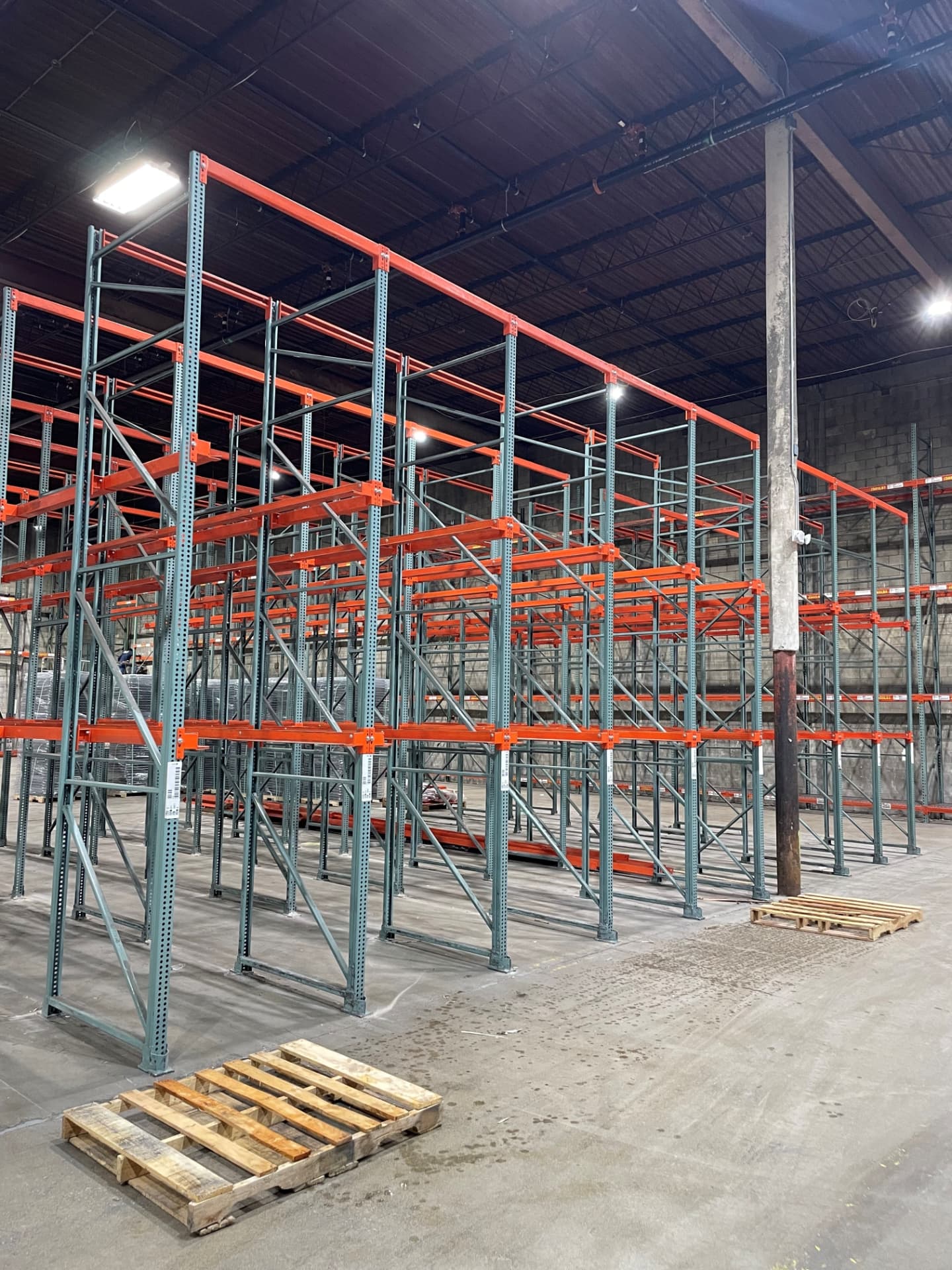 High-density blue and orange drive-in pallet racking structure in a warehouse